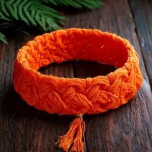 un bracelet en macramé artisanal orange posé sur du bois foncé